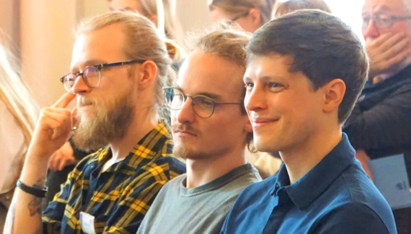 Fabian Wörz und Linus Einsiedler sitzen seitlich und lächeln.