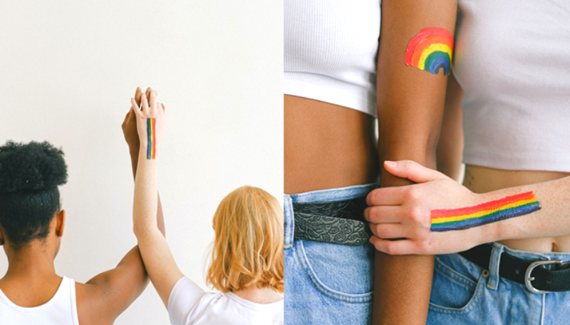 Zwei Personen die zusammen ihre Arme nach oben strecken. Auf die Arme sind Regenögen gemalt.