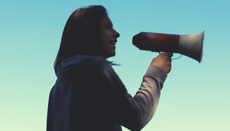 Person mit einem Megaphon in der Hand.
